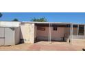 Exterior view of the side of the home with an attached shed and covered parking area, ready for renovation at 3541 W Monona Dr, Glendale, AZ 85308