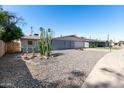 View of the front yard with desert landscaping and a single-story home featuring a two-car garage at 3811 W Loma Ln, Phoenix, AZ 85051