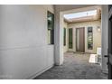 Covered entryway with stone pavers leading to a modern front door surrounded by sidelight windows at 3822 E Canyon Pl, Chandler, AZ 85249