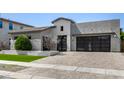 Contemporary home featuring desert landscaping, a modern facade, a tile roof and a three-car garage at 3822 E Canyon Pl, Chandler, AZ 85249