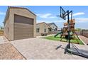 Paver patio with a play structure, basketball hoop, and artificial grass at 4091 W Suncup Dr, San Tan Valley, AZ 85144