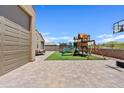 Large backyard with paver patio, play structure, and trampoline at 4091 W Suncup Dr, San Tan Valley, AZ 85144