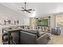 Comfortable living room with a large built-in entertainment center, ceiling fan, and a gray leather sectional at 4111 S Dewdrop Ct, Gilbert, AZ 85297