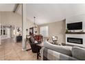 Inviting living room featuring tile flooring, a fireplace, and a seamless flow into the dining area at 4216 E Sandia St, Phoenix, AZ 85044
