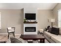 Modern living room with a fireplace, mounted TV, and a neutral color palette at 4216 E Sandia St, Phoenix, AZ 85044
