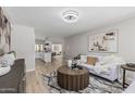 Open-concept living room with neutral tones and view into the bright, modern kitchen at 4416 E Capistrano Ave, Phoenix, AZ 85044