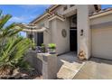 Close-up of a home's entrance with decorative wall art, potted plants, and an inviting shaded entryway at 4680 E Nightingale Ln, Gilbert, AZ 85298