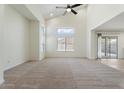 Open-concept living room with vaulted ceilings, large windows, and sliding glass doors to the backyard at 5420 W Grove St, Laveen, AZ 85339
