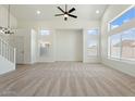 Bright and spacious living room featuring neutral carpet, high ceilings, and large windows for natural light at 5420 W Grove St, Laveen, AZ 85339