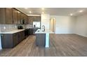Modern kitchen with wood cabinets, stainless appliances, and kitchen island with sink at 5657 S 253Rd Ave, Buckeye, AZ 85326