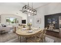 Inviting dining room area featuring modern lighting, neutral tones, and views into the living room at 6502 W Wahalla Ln, Glendale, AZ 85308