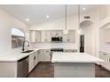 Modern kitchen with white cabinets, stainless steel appliances, and pendant lighting over the island at 6502 W Wahalla Ln, Glendale, AZ 85308