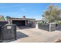 Well-kept front yard with covered parking and a charming single-story residence and blue sky at 8202 W Turney Ave, Phoenix, AZ 85033