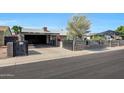 Inviting front yard with a driveway leading to a covered parking area and charming single story residence at 8202 W Turney Ave, Phoenix, AZ 85033