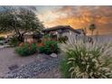 Well-manicured desert landscaping and mature trees adorn the exterior of this inviting home at 9326 E Princess Dr, Mesa, AZ 85207