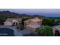 Elegant two-story home boasts desert landscaping and a three-car garage, set against a mountain backdrop at 9571 E Nittany Dr, Scottsdale, AZ 85255