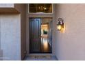 Inviting entryway features a dark wood door, decorative sconce, and 'Welcome' mat at 9571 E Nittany Dr, Scottsdale, AZ 85255