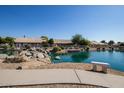 Scenic lake view with a peaceful walking path and inviting bench seating at 11065 W Runion Dr, Peoria, AZ 85373