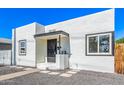 Charming white home featuring a black door, black trimmed windows, and desert landscaping at 1118 N 18Th St, Phoenix, AZ 85006