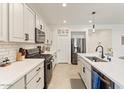 Open concept kitchen with stainless appliances, granite countertops, and tile backsplash at 11951 W Wier Ave, Avondale, AZ 85323
