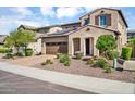 Two-story home featuring desert landscaping, tile roof, solar panels, and a two-car garage at 12932 W Cassia Trl, Peoria, AZ 85383
