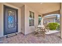 Inviting front porch featuring decorative iron door, tiled flooring and a cozy seating area at 12932 W Cassia Trl, Peoria, AZ 85383