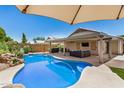 Inviting backyard oasis with a sparkling pool and covered patio, perfect for outdoor entertaining at 13216 W Desert Ln, Surprise, AZ 85374