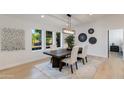 Contemporary dining room featuring a modern chandelier, neutral decor, and a view of the front yard at 14012 N 57Th Pl, Scottsdale, AZ 85254
