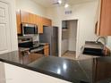 Modern kitchen boasts stainless steel appliances, granite countertops, and adjacent laundry area at 14250 W Wigwam Blvd # 1723, Litchfield Park, AZ 85340