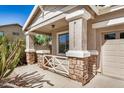 Inviting porch with stone pillars, a cozy seating area, and a secure white railing enhancing curb appeal at 1501 S 122Nd Ave, Avondale, AZ 85323