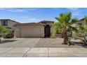 Charming home exterior featuring a two-car garage and low maintenance desert landscaping at 1641 W Windsong Dr, Phoenix, AZ 85045