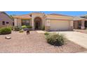Inviting single-Gathering home featuring desert landscaping, arched entryway, and two-car garage at 17805 W Arizona Dr, Surprise, AZ 85374