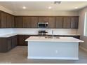 Modern kitchen with white countertop island, dark cabinets, stainless steel appliances, and tiled backsplash at 31762 N Bandit Rd, San Tan Valley, AZ 85143