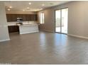 Open concept living space with tiled floors leading to the kitchen and sliding glass patio door at 31762 N Bandit Rd, San Tan Valley, AZ 85143