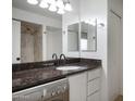 Bathroom with granite countertops, black faucet and washer/dryer unit on the left at 3619 E Monterosa St # 202, Phoenix, AZ 85018