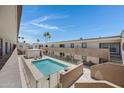 Outdoor community pool surrounded by apartment complex, palm trees and bright blue sky at 3619 E Monterosa St # 202, Phoenix, AZ 85018