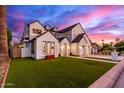 Striking two-story house with a manicured lawn, modern black and white exterior paint, and spacious three car garage at 4131 E Roma Ave, Phoenix, AZ 85018