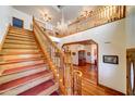 Grand foyer with soaring ceilings, wood staircase, chandelier, and hardwood floors at 424 E Lehi Rd # 2, Mesa, AZ 85203
