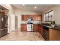 Traditional-style kitchen with stainless steel appliances, wooden cabinets and black countertop at 4731 N 86Th Dr, Phoenix, AZ 85037
