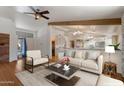 Bright living room with a ceiling fan, hardwood floors, and seamless flow to the kitchen at 4812 W Butler Dr, Chandler, AZ 85226