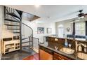 Living room with granite counter, stainless steel dishwasher, and spiral staircase to loft area at 5734 S 21St Pl, Phoenix, AZ 85040