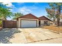 Charming single-story home featuring an attached garage and a large driveway at 6015 W Acoma Dr, Glendale, AZ 85306