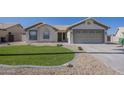 Inviting single-story home featuring a landscaped yard and a covered entrance and a two car garage at 6029 E Palm St, Mesa, AZ 85215