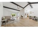 Bright and airy living room with hardwood floors, vaulted ceilings, fireplace, and sliding door to the backyard at 7319 E Rose Ln, Scottsdale, AZ 85250