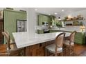 A well-appointed kitchen features green cabinetry, stainless steel appliances, and a breakfast bar with seating at 8049 E Serene St, Carefree, AZ 85377