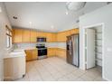 Bright kitchen features stainless steel appliances, light wood cabinets, and tile flooring at 1037 E Baylor Ln, Gilbert, AZ 85296