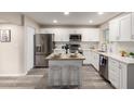 Contemporary kitchen featuring stainless steel appliances, white cabinets, and stylish island seating at 10516 W Peoria Ave, Sun City, AZ 85351