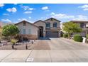 Well-maintained two-story home with a three-car garage, desert landscaping, and paved walkway at 1124 E Jahns Dr, Casa Grande, AZ 85122