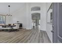 Bright dining room with wood floors, high ceilings, stylish lighting, and open view to the kitchen at 11257 E Reginald Ave, Mesa, AZ 85212