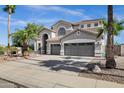 Charming two-story home featuring a three-car garage, desert landscaping, and mature palm trees at 11257 E Reginald Ave, Mesa, AZ 85212